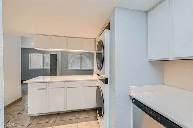 laundry room featuring stacked washer / drying machine and light tile patterned floors