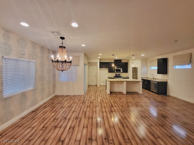 kitchen featuring a center island, appliances with stainless steel finishes, light hardwood / wood-style flooring, and pendant lighting