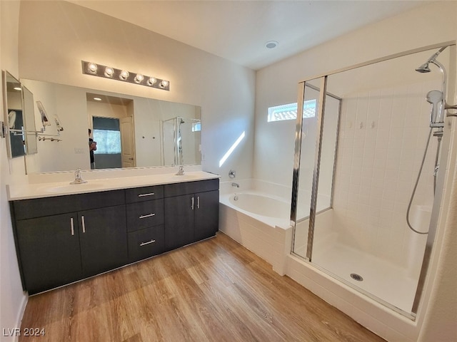 bathroom featuring vanity, a healthy amount of sunlight, wood-type flooring, and shower with separate bathtub