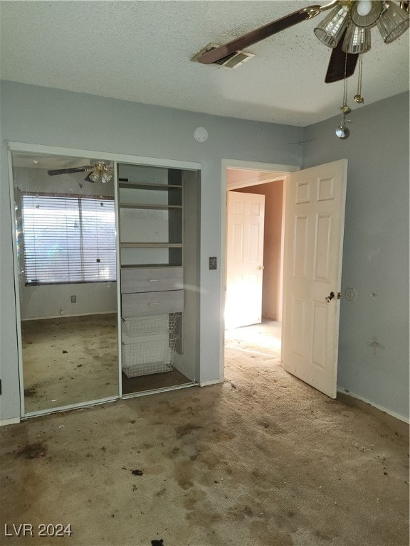 unfurnished bedroom featuring a closet, a textured ceiling, carpet flooring, and ceiling fan