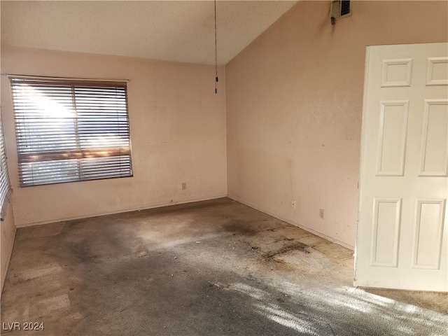 carpeted spare room with lofted ceiling