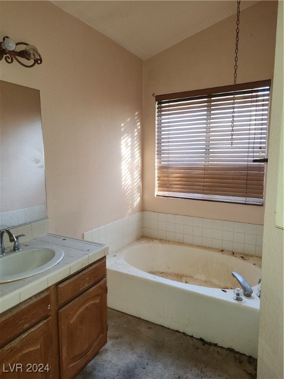 bathroom with vanity, vaulted ceiling, and a bath