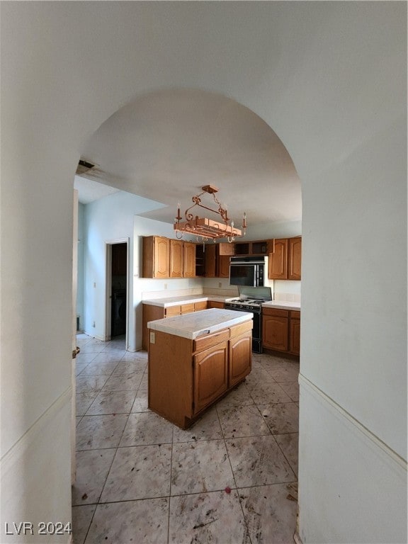 kitchen with hanging light fixtures, a center island, and range with gas stovetop