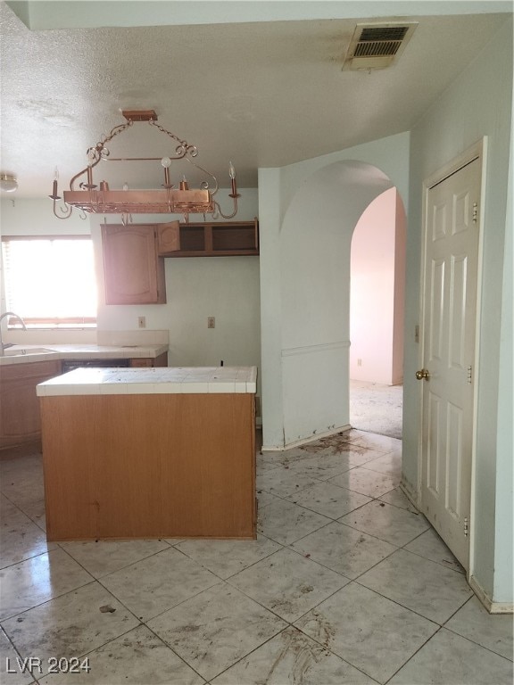 kitchen featuring a textured ceiling and sink