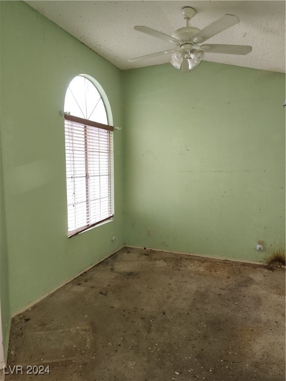 unfurnished room featuring a textured ceiling, concrete flooring, and ceiling fan