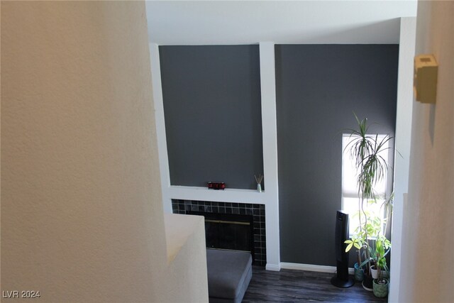 interior space featuring hardwood / wood-style flooring and a tiled fireplace