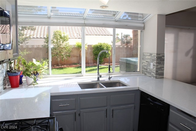 kitchen with a wealth of natural light, sink, black appliances, and gray cabinets