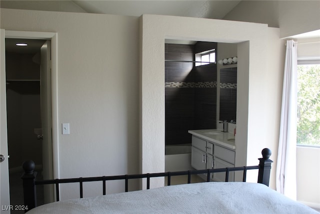 bedroom with lofted ceiling, sink, multiple windows, and a closet