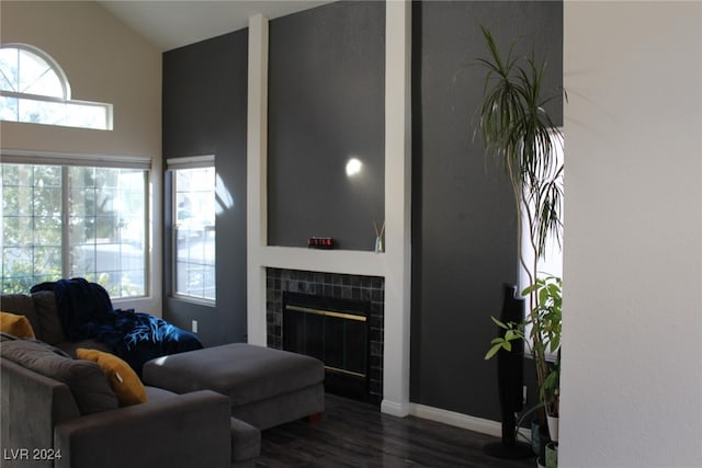 living room with lofted ceiling, a fireplace, dark hardwood / wood-style floors, and plenty of natural light