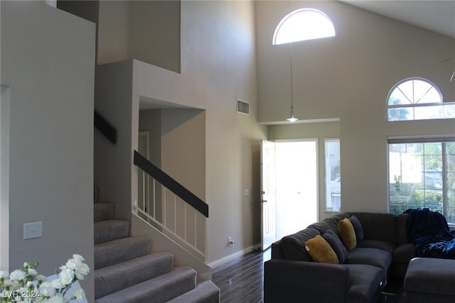 living room featuring high vaulted ceiling and dark hardwood / wood-style floors