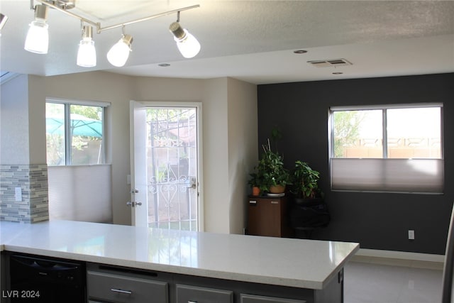 kitchen featuring tile patterned floors, dishwasher, and a textured ceiling