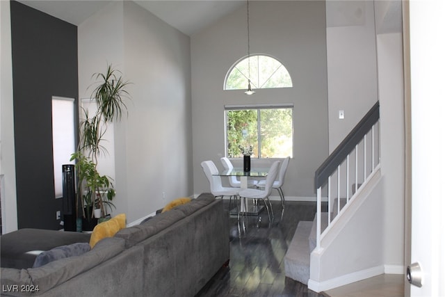 living room with high vaulted ceiling and dark wood-type flooring