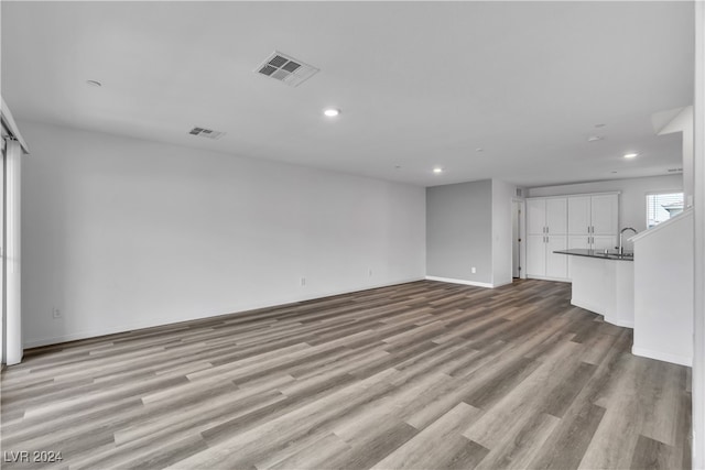 unfurnished living room with sink and light wood-type flooring