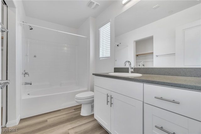 full bathroom with toilet, vanity, wood-type flooring, and tub / shower combination