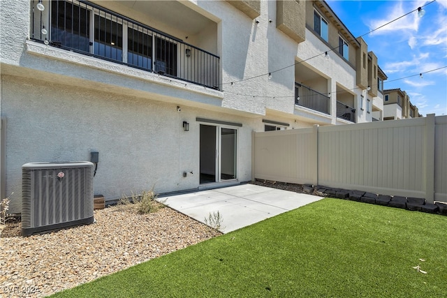 back of house with a patio area, cooling unit, a lawn, and a balcony