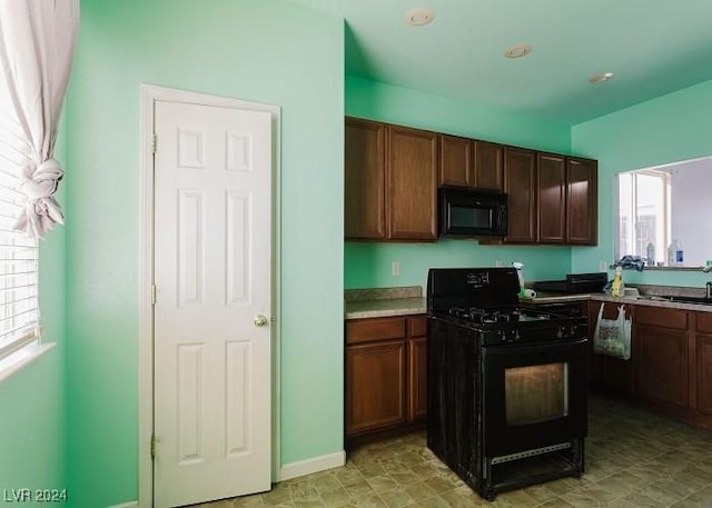 kitchen with dark brown cabinetry and black appliances