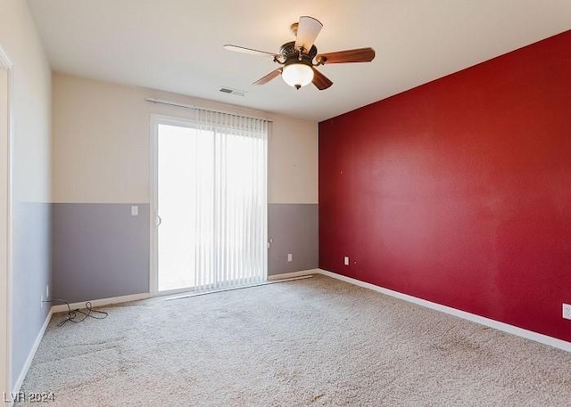 carpeted spare room featuring ceiling fan