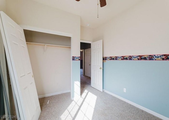 unfurnished bedroom featuring a closet, light colored carpet, and ceiling fan