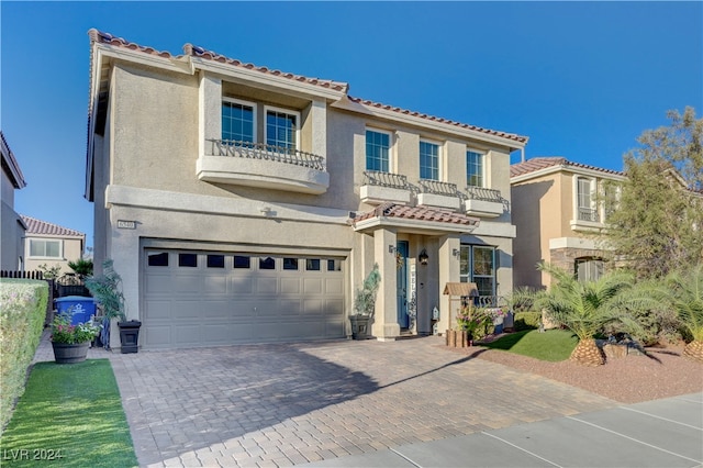 mediterranean / spanish-style home with a garage and a balcony