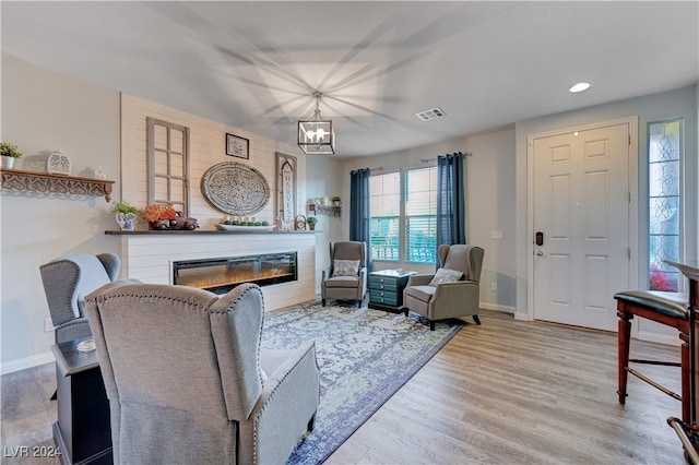 living room with light wood-type flooring and an inviting chandelier