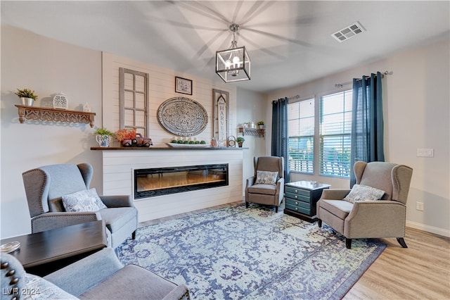 living room with light hardwood / wood-style floors and an inviting chandelier