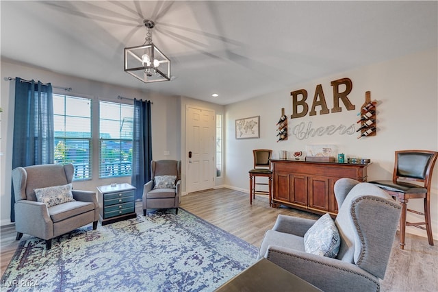 living area featuring light wood-type flooring and a chandelier