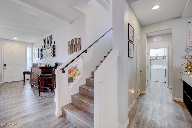 staircase featuring hardwood / wood-style floors and independent washer and dryer