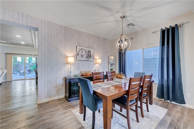 dining room featuring crown molding, light hardwood / wood-style floors, and an inviting chandelier