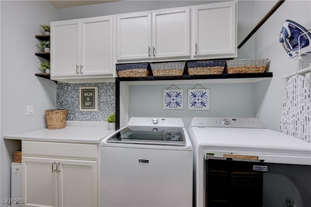 clothes washing area featuring separate washer and dryer and cabinets