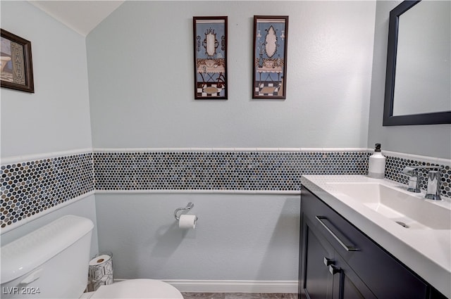 bathroom with vanity, toilet, and vaulted ceiling