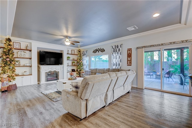 living room with ceiling fan, light hardwood / wood-style flooring, and ornamental molding