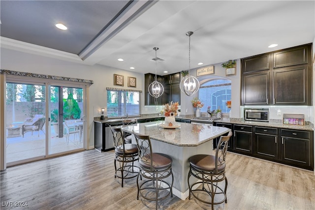 kitchen with a kitchen breakfast bar, a center island, a notable chandelier, and light wood-type flooring