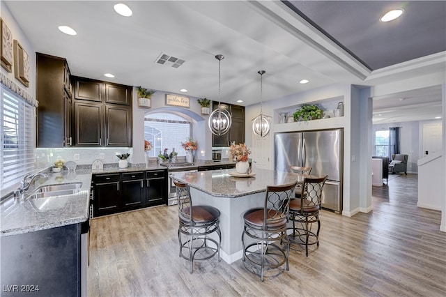 kitchen featuring pendant lighting, a center island, stainless steel appliances, and a wealth of natural light