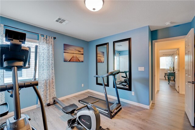 workout room featuring light wood-type flooring