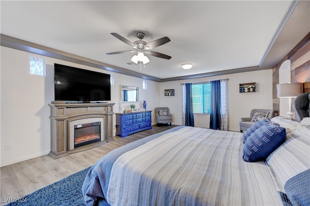 bedroom with ceiling fan, ornamental molding, multiple windows, and light hardwood / wood-style flooring