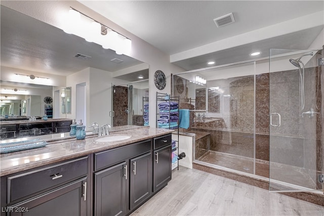 bathroom featuring vanity, wood-type flooring, and a shower with shower door