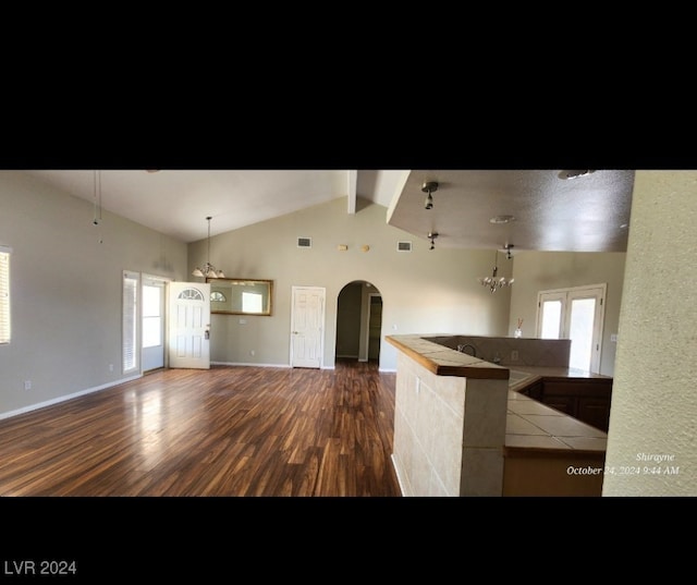 kitchen featuring vaulted ceiling with beams, an inviting chandelier, and dark hardwood / wood-style flooring