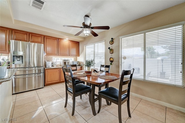 tiled dining space with ceiling fan