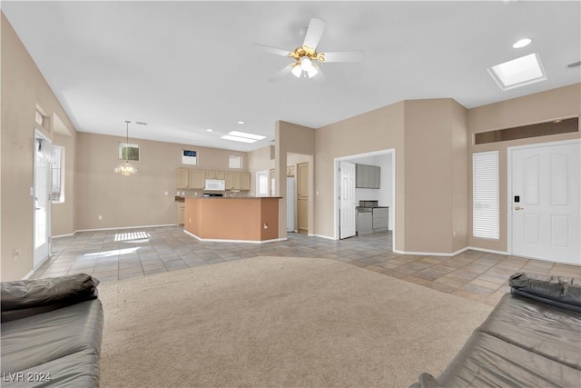 carpeted living room featuring a skylight, plenty of natural light, and ceiling fan