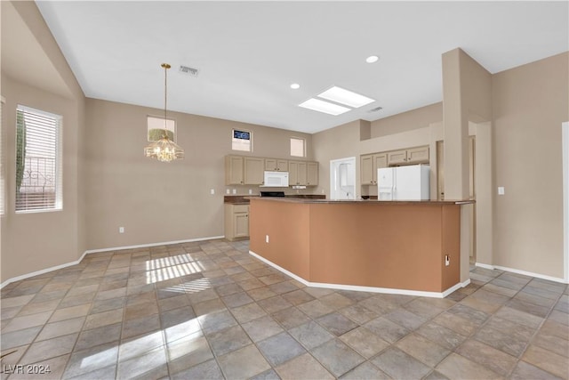 kitchen with a skylight, pendant lighting, white appliances, and an inviting chandelier