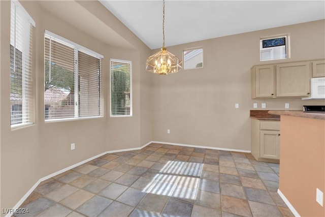 unfurnished dining area with vaulted ceiling, an inviting chandelier, and a healthy amount of sunlight