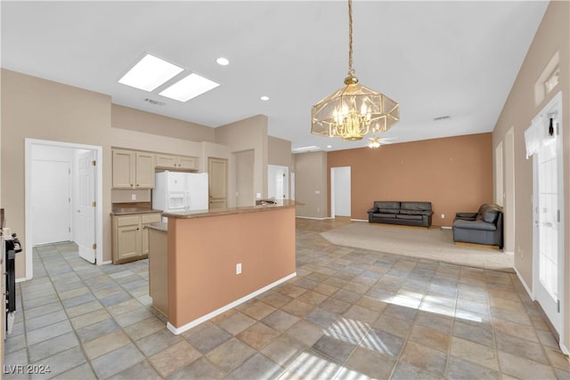 kitchen featuring hanging light fixtures, cream cabinetry, an inviting chandelier, and white fridge with ice dispenser