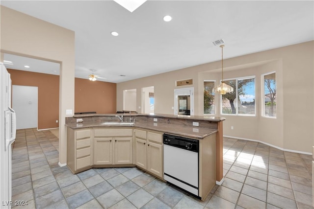 kitchen with dishwasher, cream cabinets, ceiling fan with notable chandelier, sink, and light stone countertops