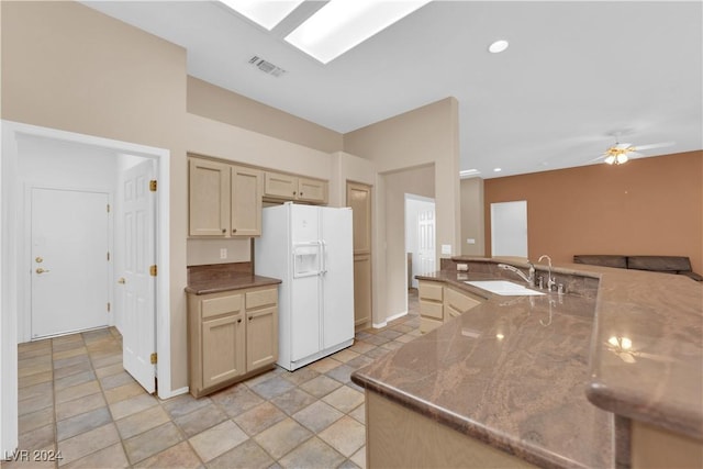 kitchen with white refrigerator with ice dispenser, ceiling fan, and sink