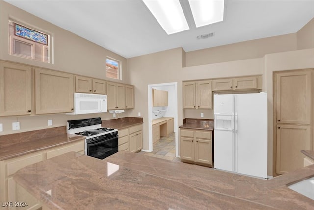 kitchen featuring light brown cabinetry and white appliances