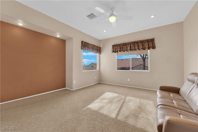 unfurnished living room with ceiling fan and carpet