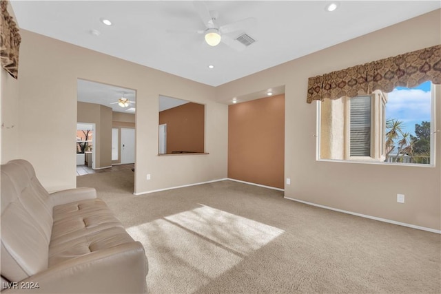 unfurnished living room featuring light colored carpet and ceiling fan