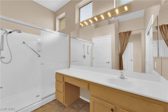 bathroom with tile patterned flooring, vanity, and walk in shower