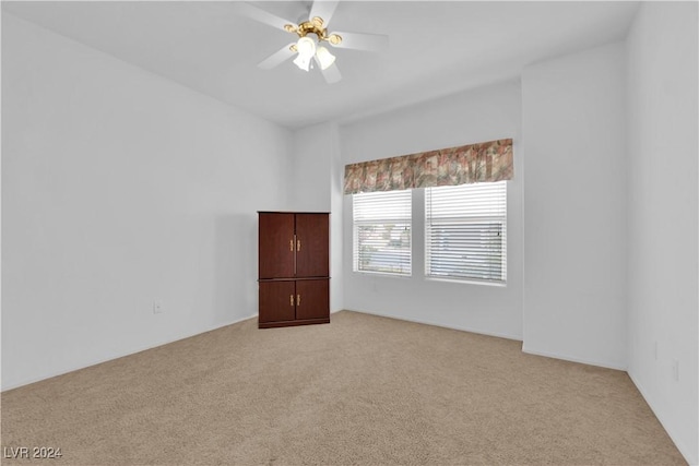 unfurnished room with light colored carpet and ceiling fan