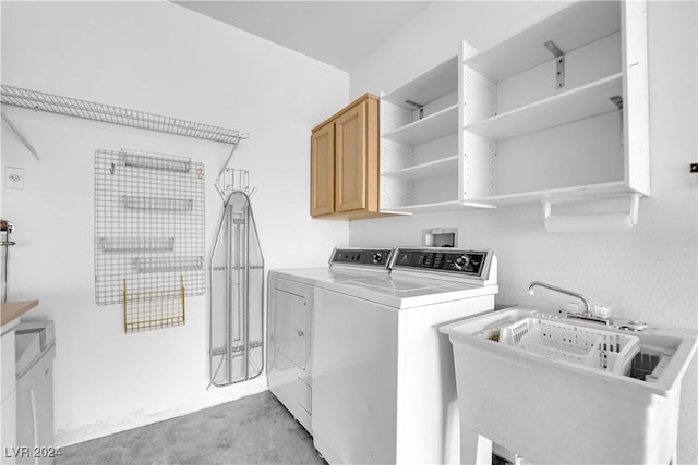 laundry room featuring cabinets, washing machine and dryer, and sink